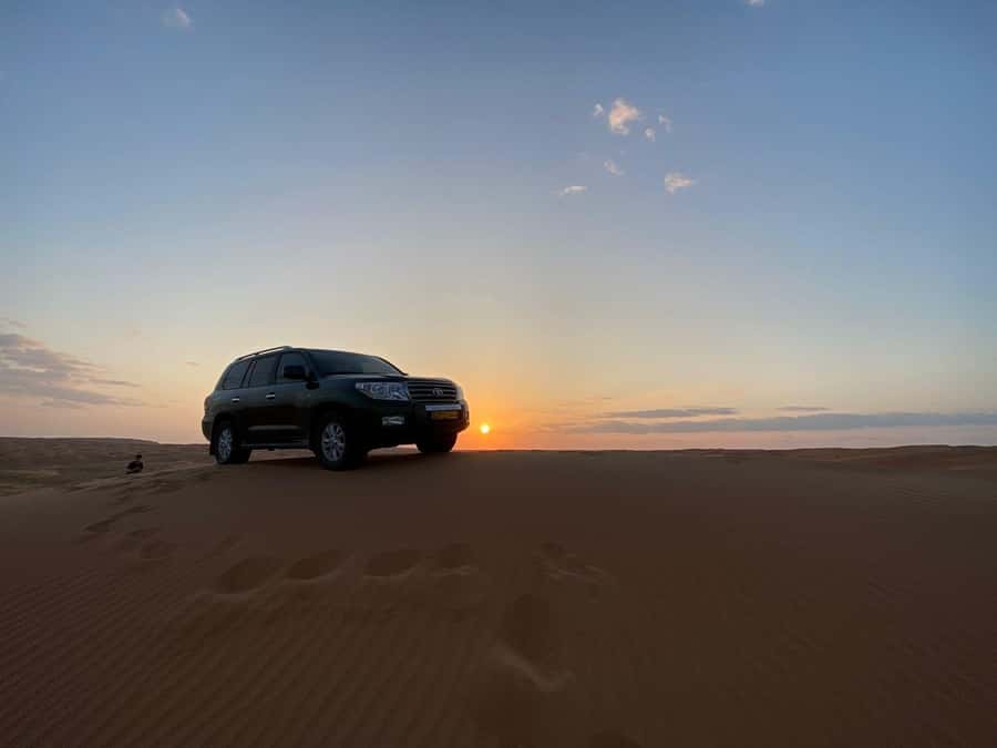 From Muscat: Wahiba Sands Sunset with Desert Camp Dinner - Camel riding across the Wahiba sand