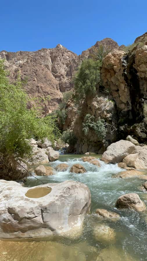 Muscat: Wadi Shab, Romantic Cave and Sinkhole Full-day Trip - Walking into Wadi Shab